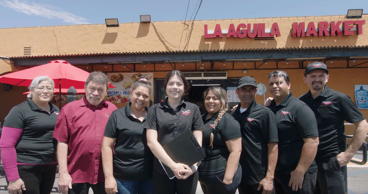 Daisy Cuevas with her parents and the staff of La Aguila Market