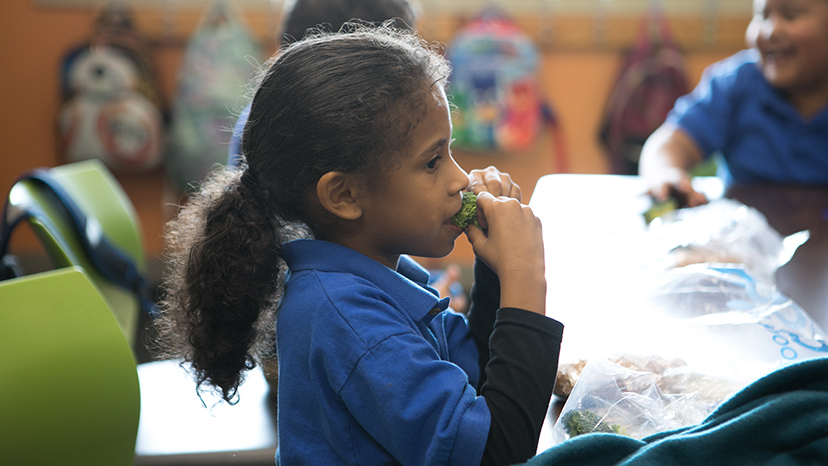 A girl in Dallas samples some broccoli.