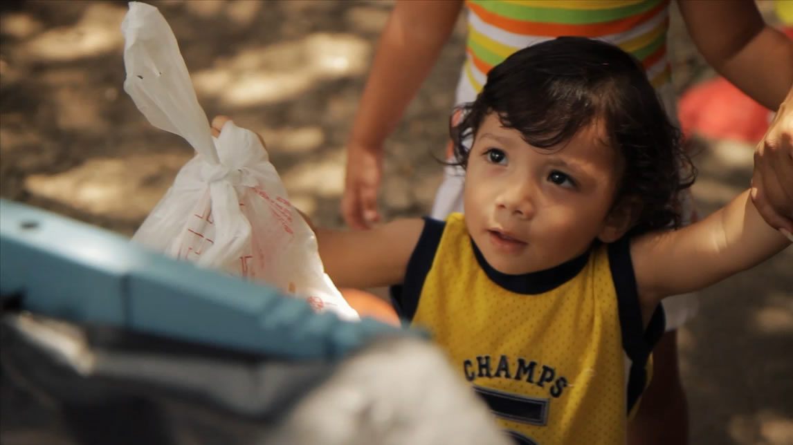 Child holding a plastic bag filled with food